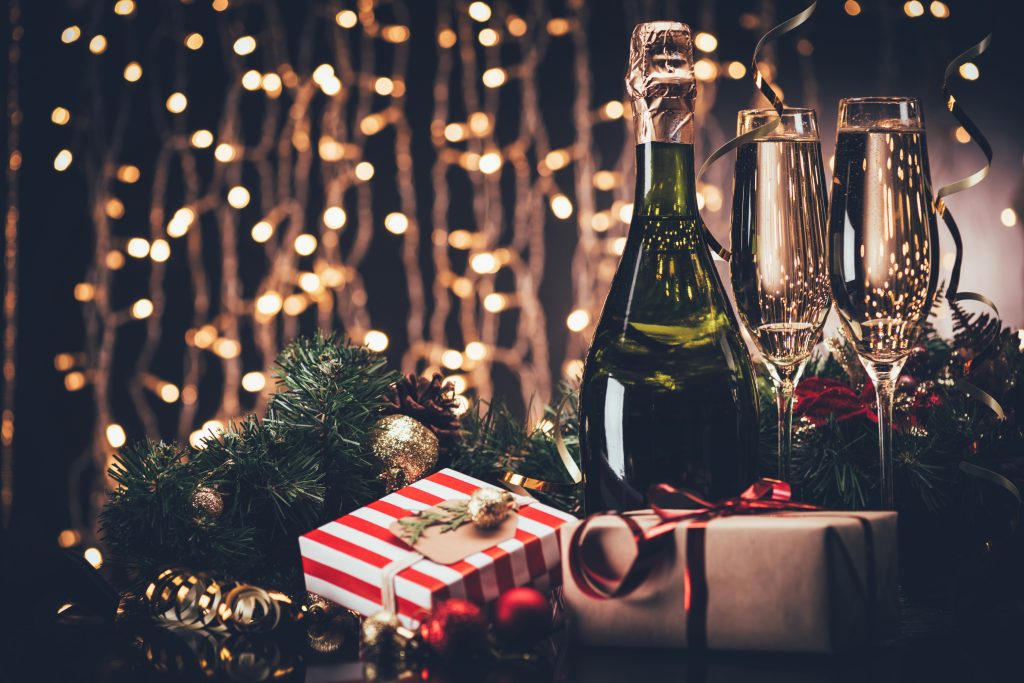 About Champagne: Bottle of Champagne and a full glass with a muted Christmas background