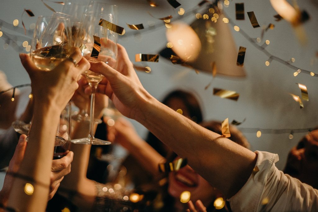 people toasting with champagne as confetti falls 